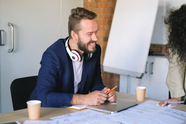 hombre sonriendo a otra persona en reunión