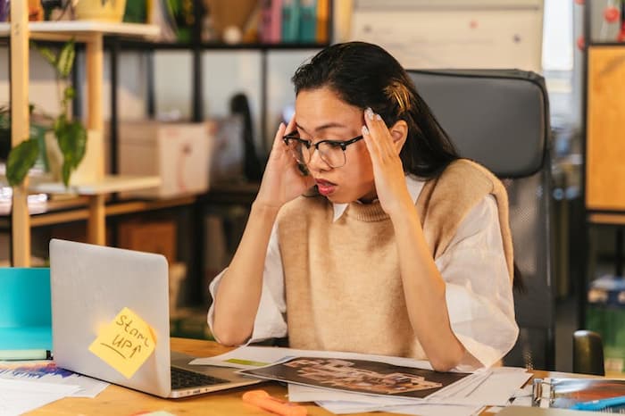 worried woman looking a laptop screen