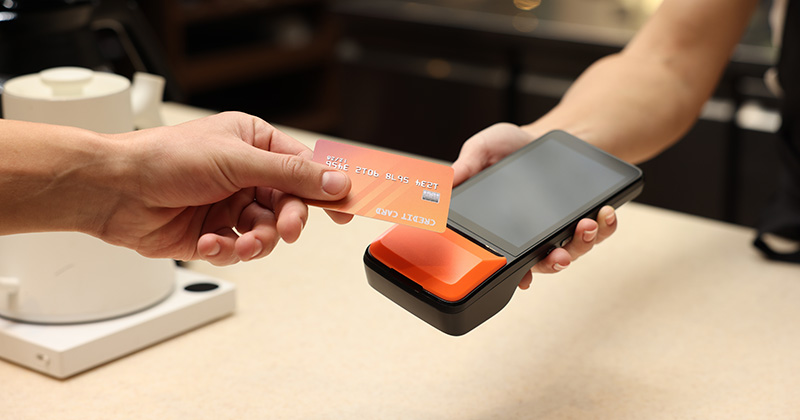 Orange-credit-card-using-contactless-pay-on-a-payment-terminal.