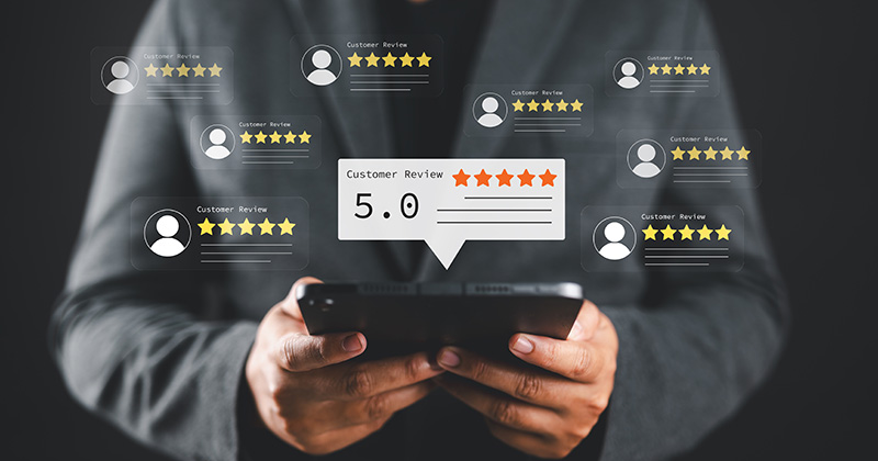 A-man-in-work-overalls-holding-a-tablet-with-graphics-of-5-star-reviews-overlaid.