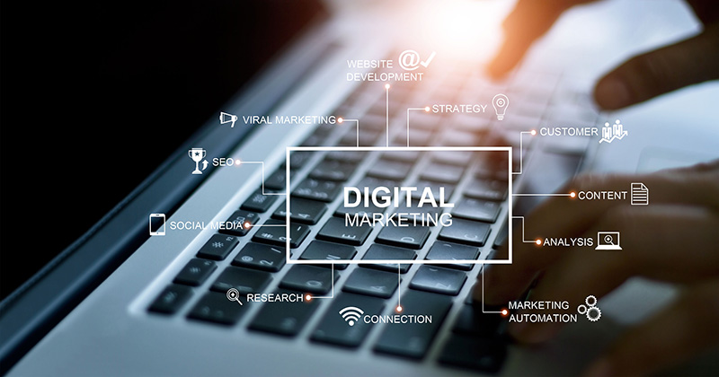Hands-at-a-laptop-with-an-overlay-of-the-text-_Digital-Marketing.