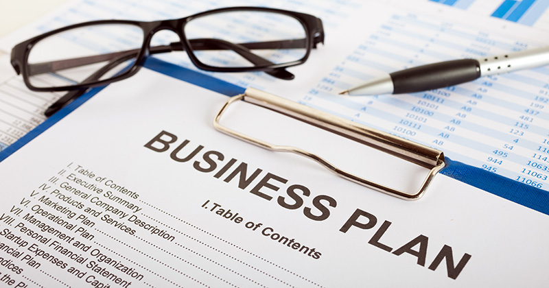 Un-clipboard-con-un-documento-titulado-_Business-Plan_que-enumera-varios-puntos-de-bullet.